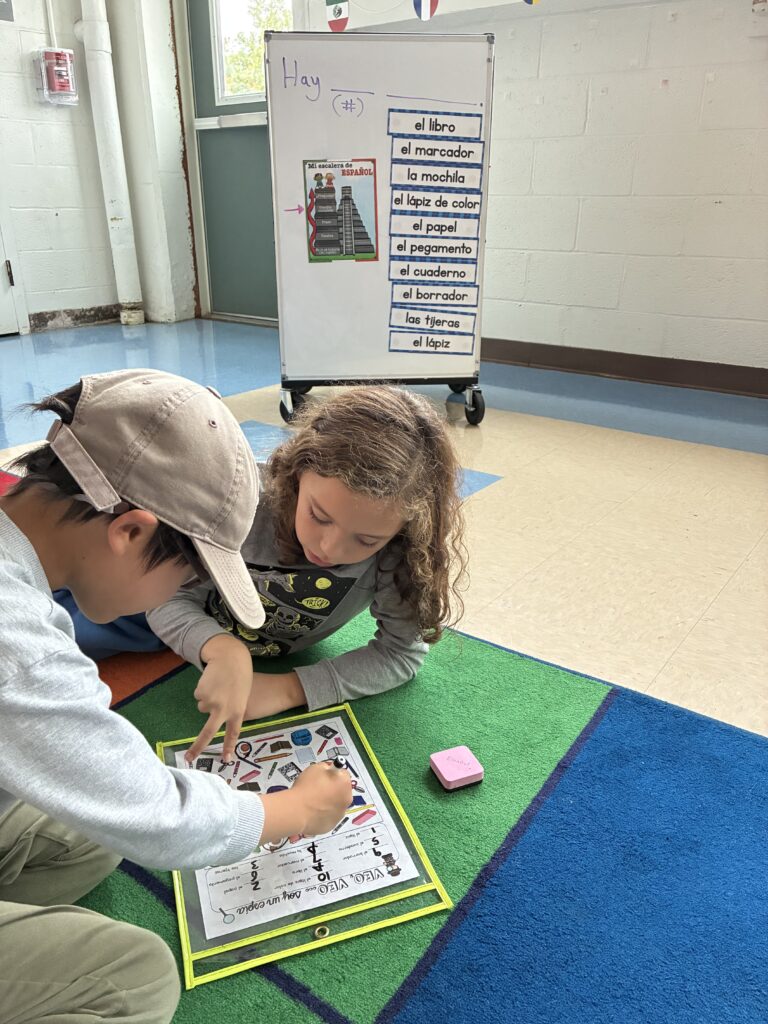 Two students working together on vocabulary on a colorful rug